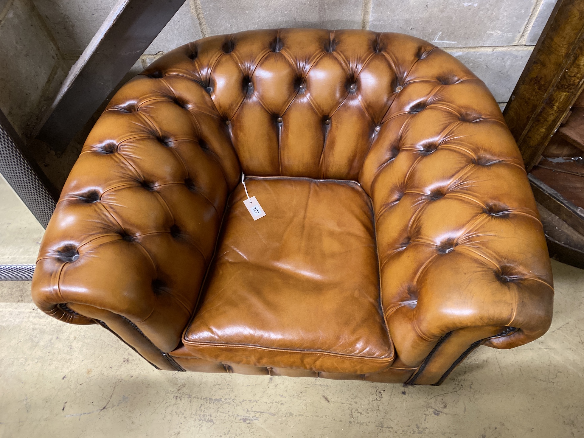 A Victorian style tan leather Chesterfield type armchair, width 102cm, depth 84cm, height 60cm